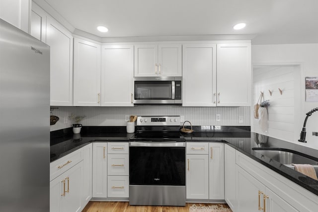 kitchen featuring white cabinetry, stainless steel appliances, a sink, and recessed lighting