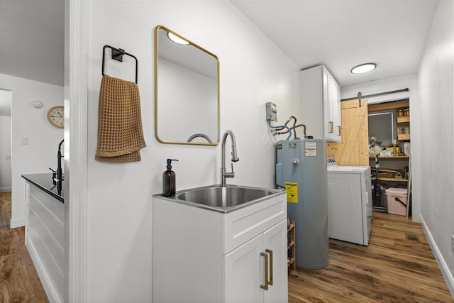 laundry room featuring a barn door, electric water heater, laundry area, a sink, and washer / clothes dryer