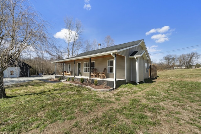 rear view of house with a porch and a yard