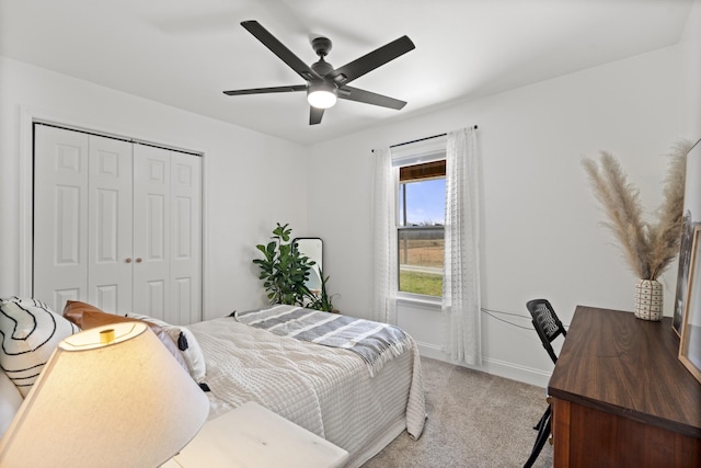 carpeted bedroom featuring a ceiling fan, baseboards, and a closet