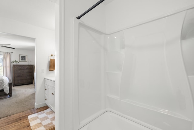 full bath featuring wood finished floors, vanity, a ceiling fan, a shower, and ensuite bath