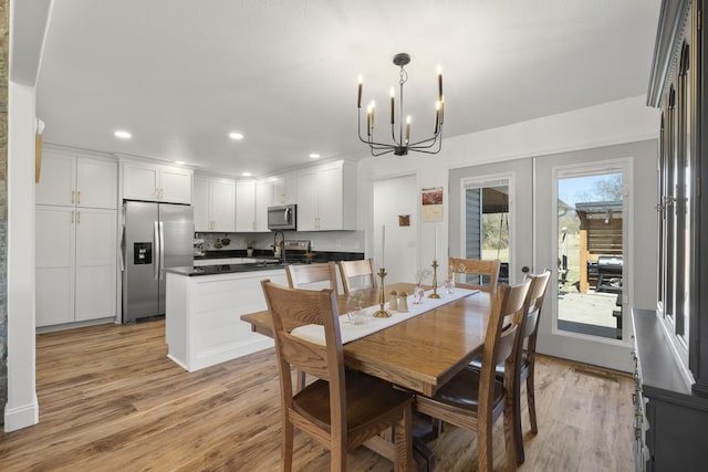 dining room with a chandelier, light wood-type flooring, french doors, and recessed lighting