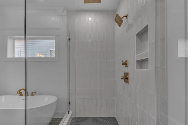 full bathroom with tiled shower and a soaking tub