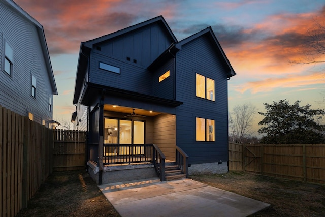 back of property featuring board and batten siding, a patio area, a fenced backyard, and a ceiling fan