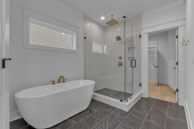 bathroom with recessed lighting, a freestanding tub, a shower stall, and baseboards