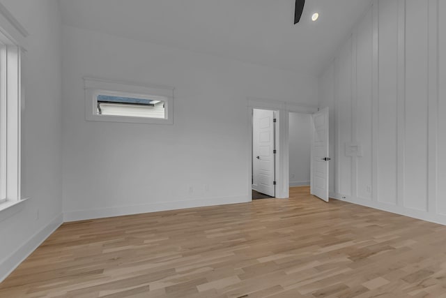 interior space with light wood-style floors, vaulted ceiling, ceiling fan, and baseboards