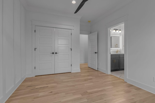 unfurnished bedroom with a ceiling fan, baseboards, a closet, light wood finished floors, and ensuite bath