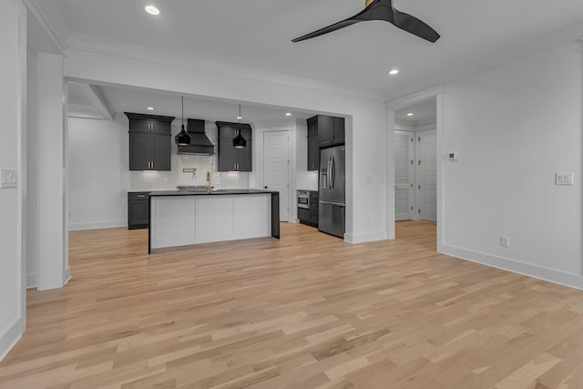 kitchen with premium range hood, a sink, open floor plan, stainless steel fridge with ice dispenser, and light wood finished floors