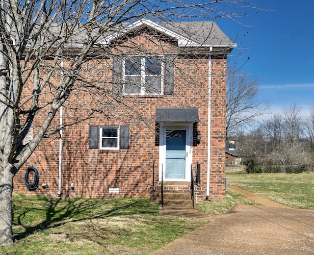 view of front of house featuring brick siding, crawl space, and a front yard