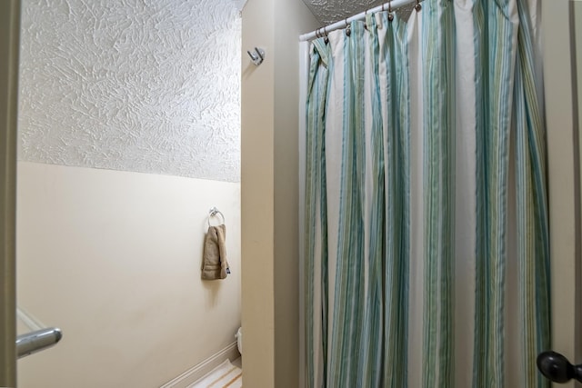 bathroom with lofted ceiling, a textured ceiling, and a shower with shower curtain