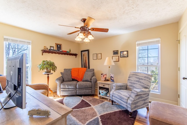 living room with a healthy amount of sunlight, ceiling fan, a textured ceiling, and wood finished floors