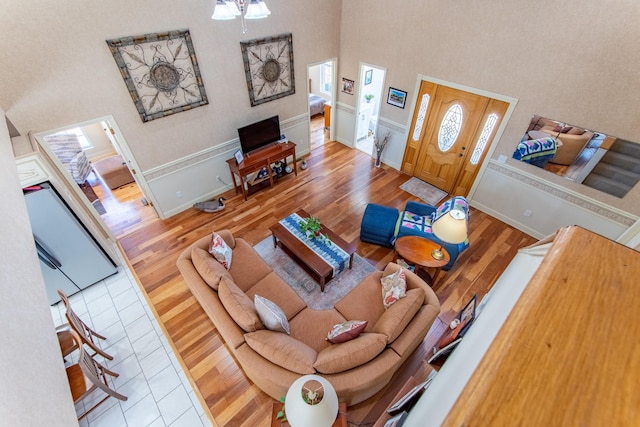 living room with baseboards, a high ceiling, and wood finished floors