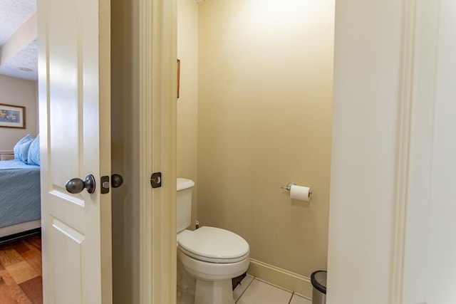 bathroom featuring tile patterned flooring, baseboards, connected bathroom, and toilet