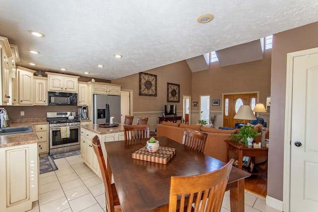 dining area featuring light tile patterned floors, vaulted ceiling, a textured ceiling, and recessed lighting