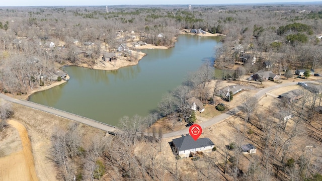 birds eye view of property featuring a water view and a wooded view