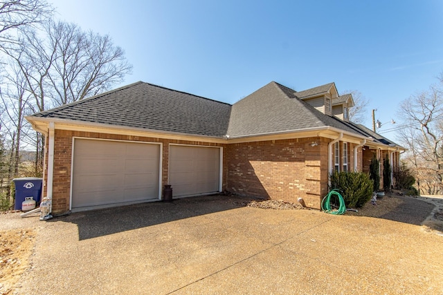 view of home's exterior with a garage, concrete driveway, brick siding, and a shingled roof