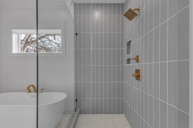 full bathroom featuring a freestanding tub and tiled shower