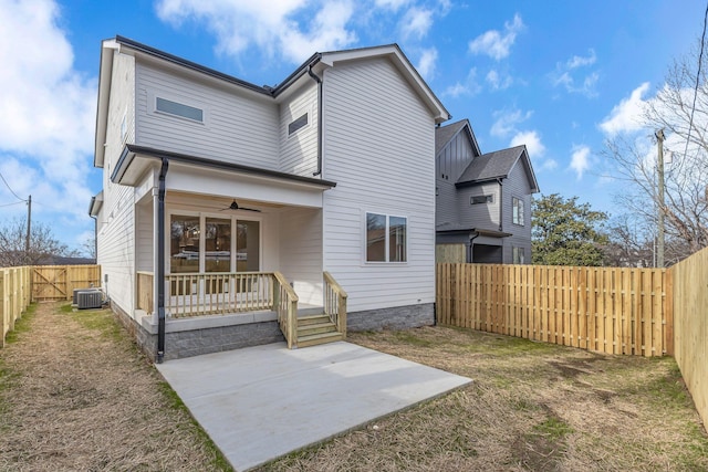 rear view of house with ceiling fan, a fenced backyard, cooling unit, a lawn, and a patio area