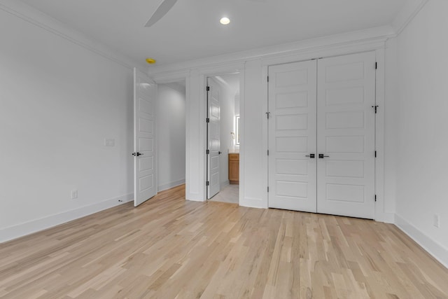 unfurnished bedroom featuring light wood-type flooring, ensuite bath, and baseboards