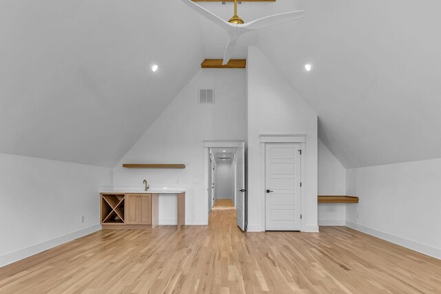 bonus room featuring baseboards, visible vents, vaulted ceiling, light wood-style floors, and a sink