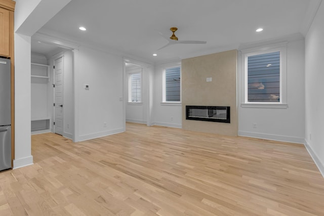 unfurnished living room with a ceiling fan, crown molding, light wood-style floors, a fireplace, and recessed lighting