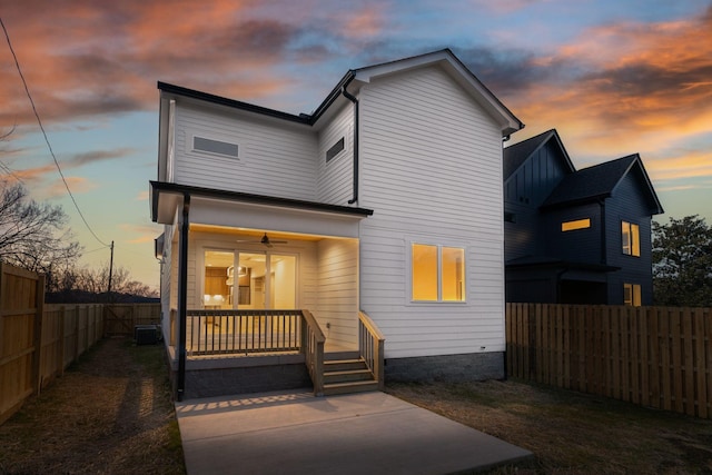 back of house featuring covered porch, a fenced backyard, and central AC unit