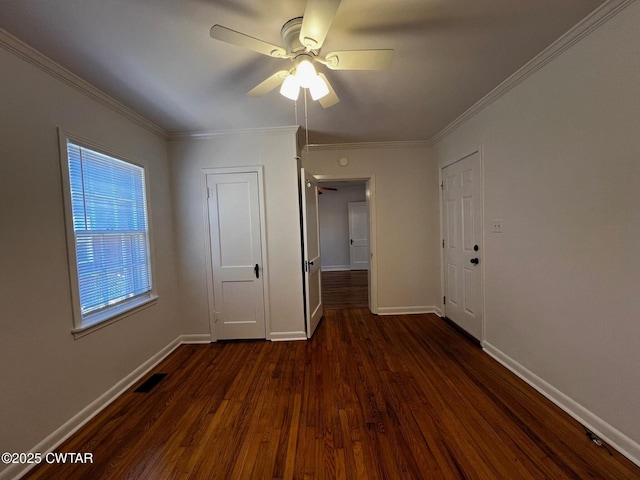 empty room featuring visible vents, baseboards, a ceiling fan, dark wood finished floors, and crown molding