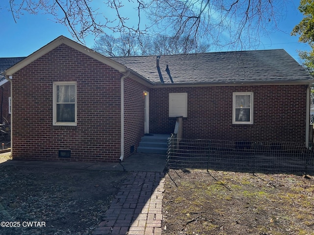 view of front of property with crawl space, a shingled roof, and brick siding