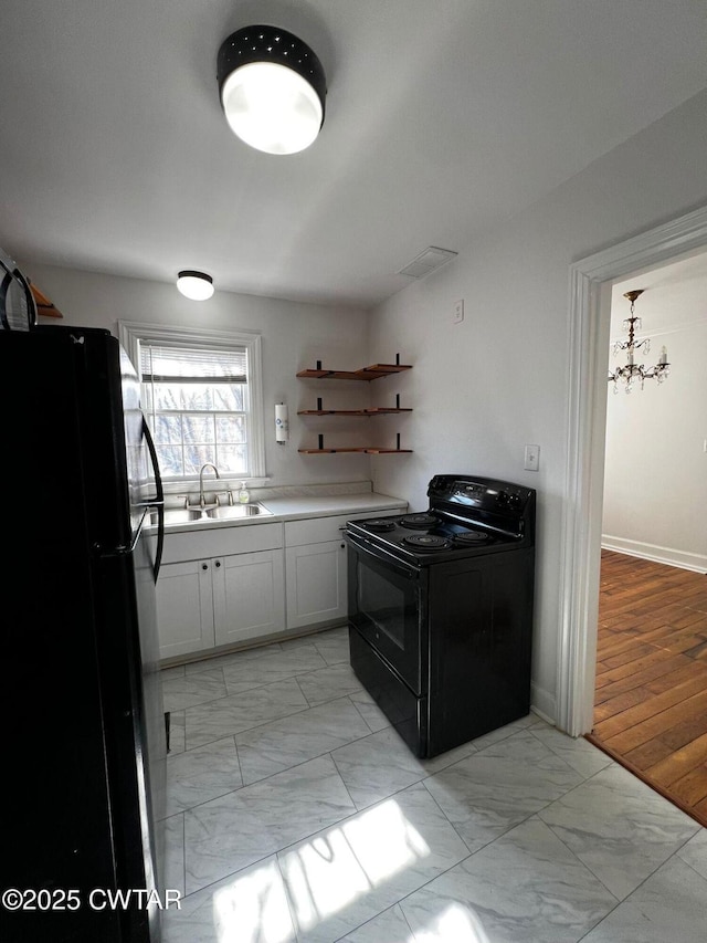 kitchen with marble finish floor, a sink, black appliances, and open shelves