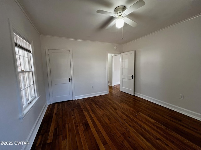 unfurnished bedroom featuring dark wood-type flooring, ornamental molding, baseboards, and ceiling fan