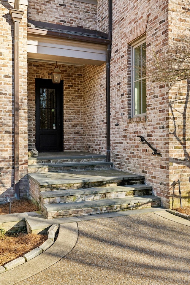 doorway to property featuring brick siding