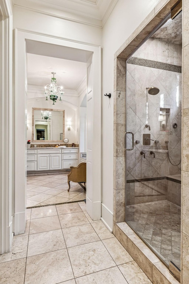 bathroom featuring baseboards, ornamental molding, vanity, a shower stall, and a chandelier