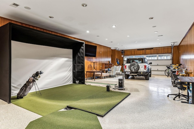 game room with golf simulator, light speckled floor, recessed lighting, visible vents, and wood walls