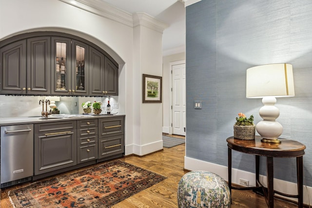 bar with ornamental molding, baseboards, and wood finished floors