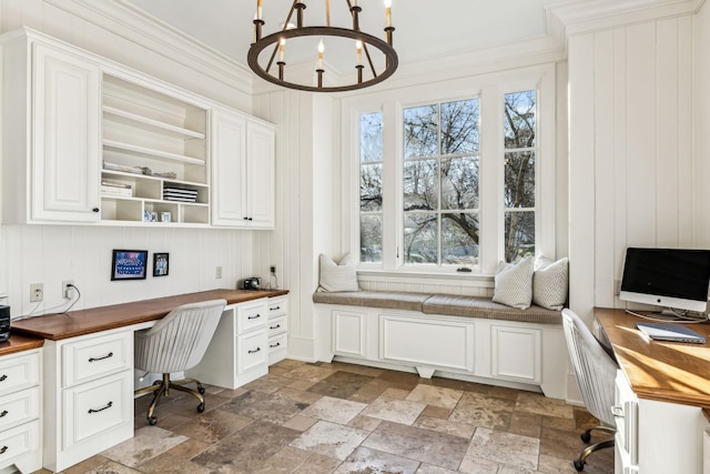 home office with a chandelier, ornamental molding, stone tile flooring, and built in study area