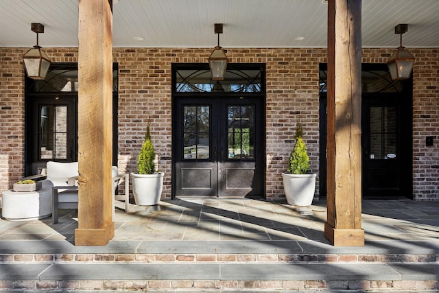 entrance to property featuring french doors and brick siding