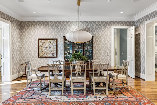 dining area with wallpapered walls, baseboards, and crown molding