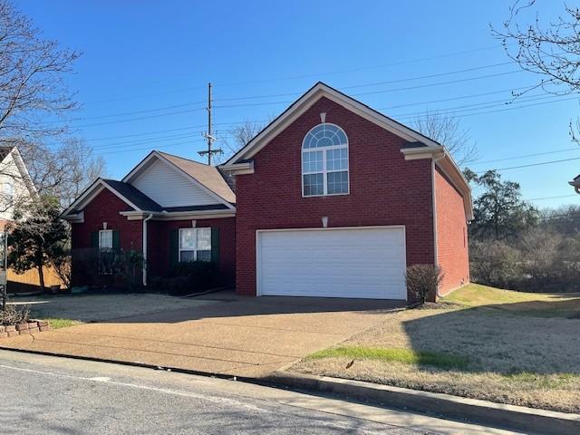 view of front facade featuring a garage, brick siding, and concrete driveway