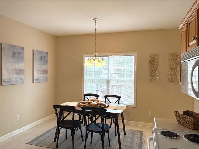 dining area featuring baseboards and a chandelier