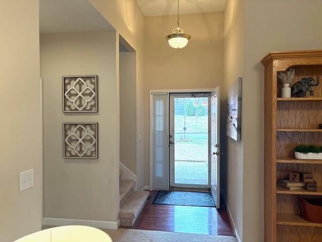 foyer featuring stairway, wood finished floors, and baseboards