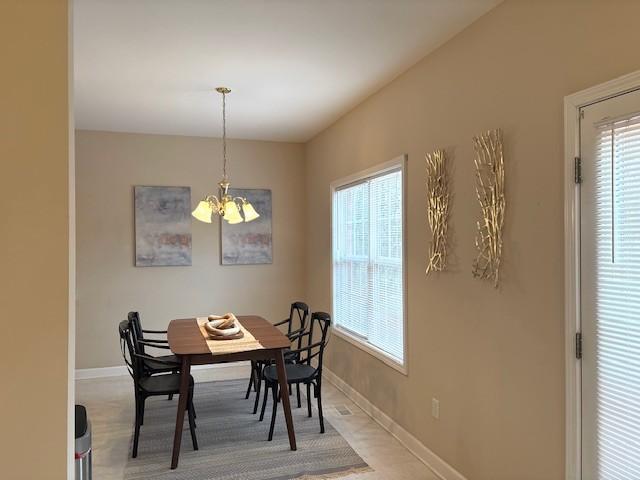 dining room with baseboards and a notable chandelier