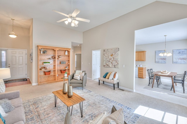 living room featuring light carpet, ceiling fan, high vaulted ceiling, and baseboards