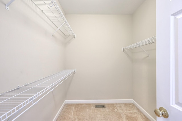 spacious closet with visible vents and light carpet