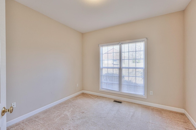 empty room with baseboards, visible vents, and carpet floors