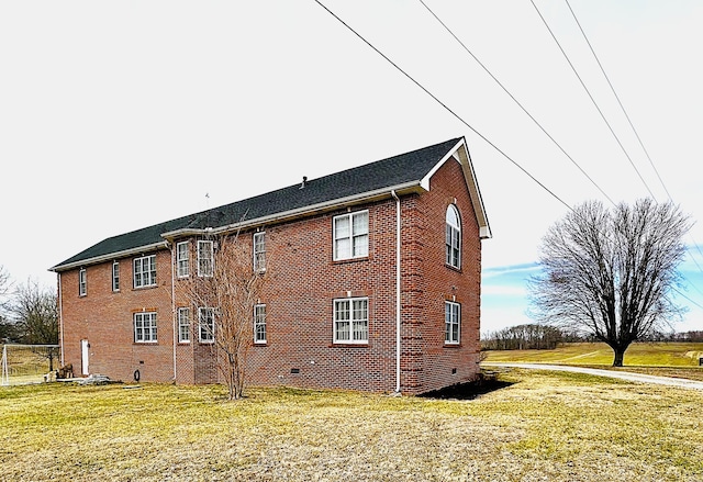 view of property exterior featuring crawl space, brick siding, and a yard