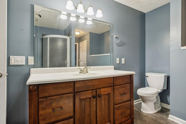 bathroom with toilet, a shower stall, vanity, tile patterned flooring, and baseboards