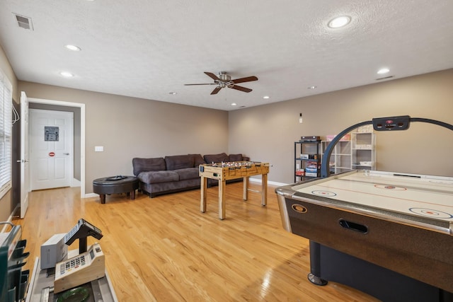 game room with a textured ceiling, recessed lighting, a ceiling fan, baseboards, and light wood-type flooring