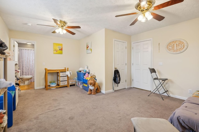 rec room with a textured ceiling, carpet, a ceiling fan, and baseboards