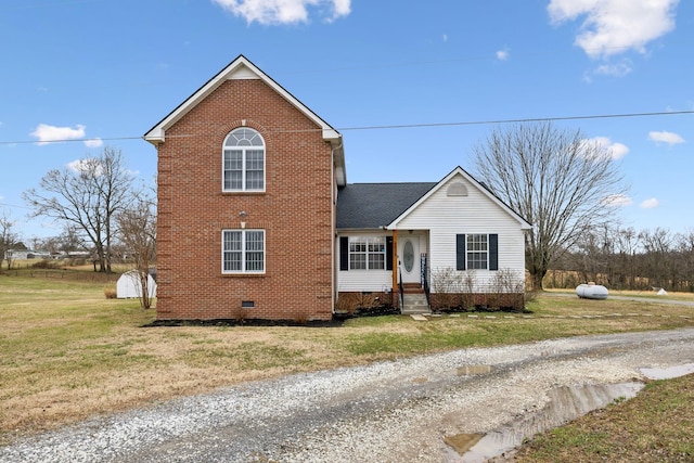 traditional-style home with a front yard, crawl space, brick siding, and entry steps