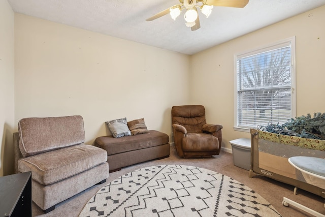 living room with a ceiling fan, carpet, and baseboards